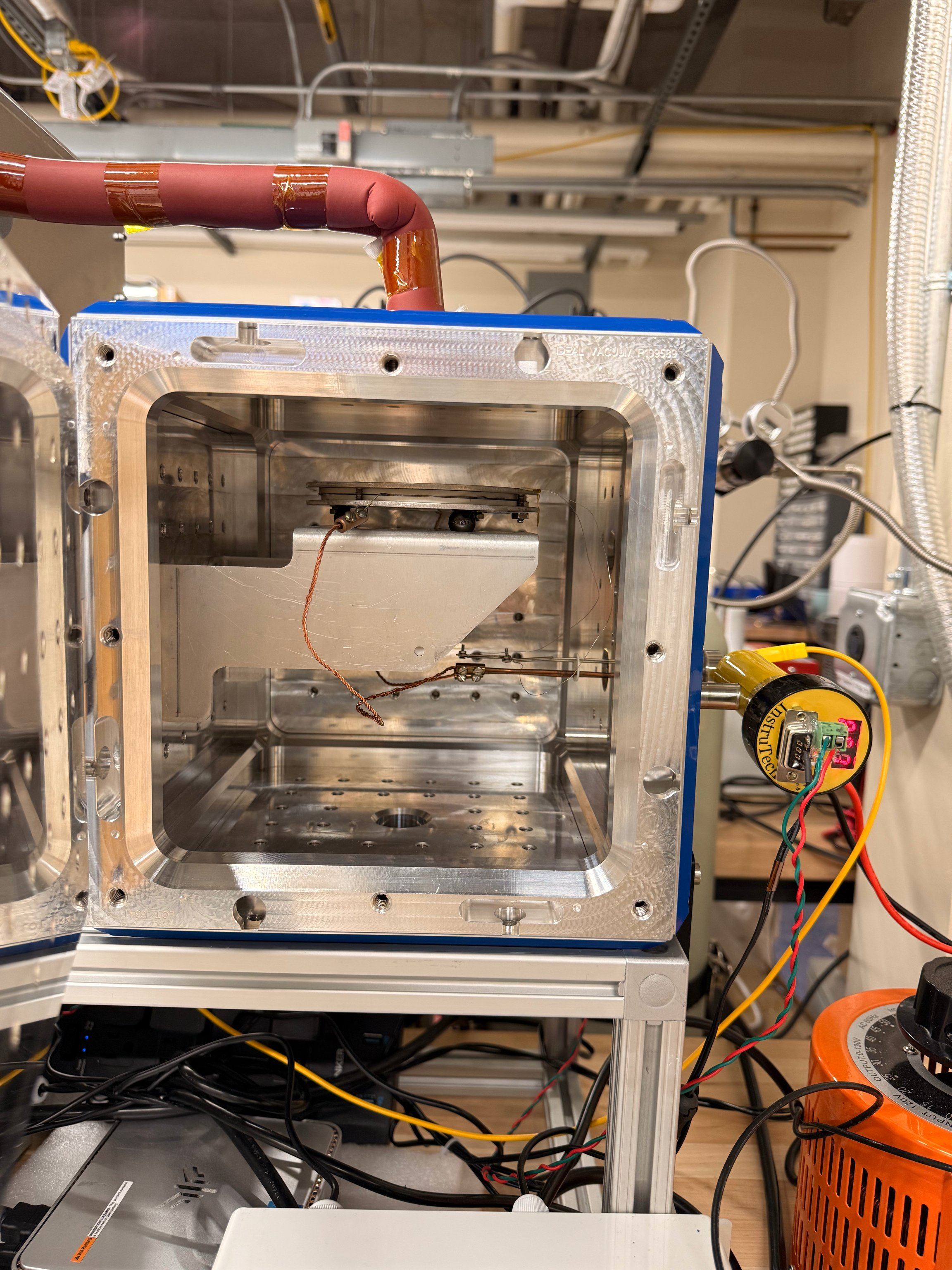 Open ALD process chamber with substrate heater, surrounding plumbing, thermocouple leads, and power hardware.